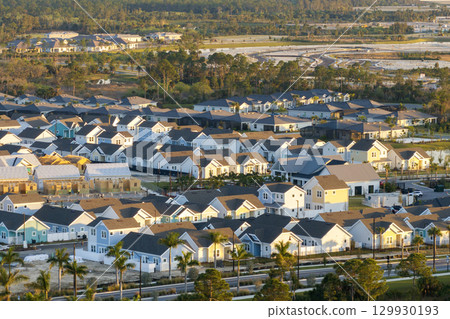 Wooden frames of new cheap American homes under construction. Development of residential housing in the USA Wooden frames of new cheap American homes under construction. Development of residential housing in the USA 129930193