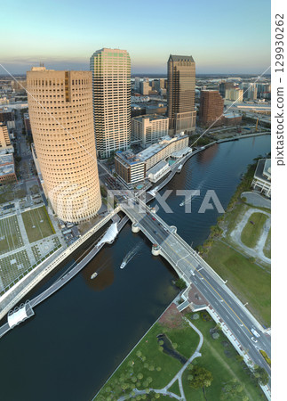 Tampa city in Florida with brightly illuminated skyscraper buildings in downtown district. American megapolis with business financial district at sunset Tampa city in Florida with brightly illuminated skyscraper buildings in downtown district. American megapolis with business financial district at sunset 129930262