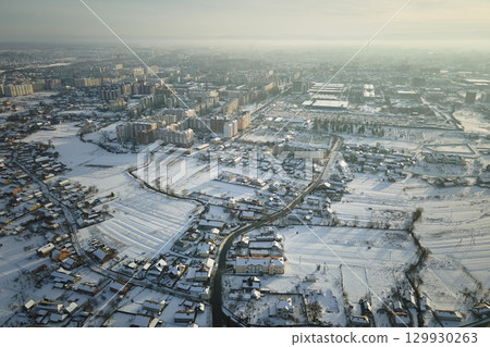 Aerial view of residential houses with snow covered roofops in suburban rural town area in winter 129930263