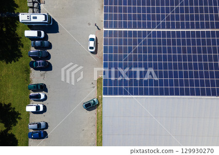 Office building with solar roof. Blue photovoltaic panels for producing clean ecological electric energy. Investing in renewable electricity concept 129930270