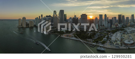 Aerial view of Skyviews Miami Observation Wheel at Bayside Marketplace with reflections in Biscayne Bay water and high illuminated skyscrapers of Brickell, city's financial center at sunset 129930281