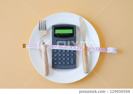 Calorie counting,Calculator in plate with a fork and a knife . 129930509