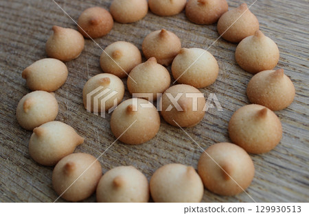 Freshly Baked Small Biscuit Cookies Laid Out In Even Circles On A Wooden Board Freshly Baked Small Biscuit Cookies Laid Out In Even Circles On A Wooden Board 129930513