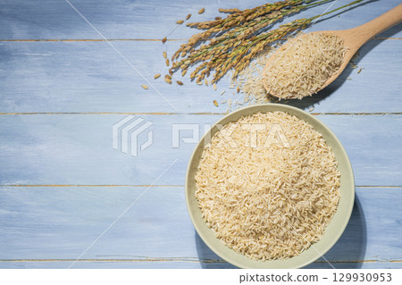 Overhead view of a green bowl filled with brown rice 129930953