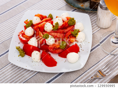 Traditional appetizer of Italian cuisine is Caprese with pesto sauce Traditional appetizer of Italian cuisine is Caprese with pesto sauce 129930995