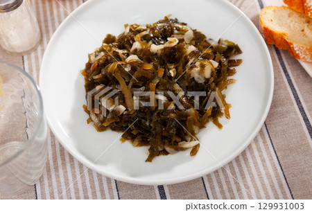 Marinated seaweed salad with onion served in plate. Asian cuisine Marinated seaweed salad with onion served in plate. Asian cuisine 129931003