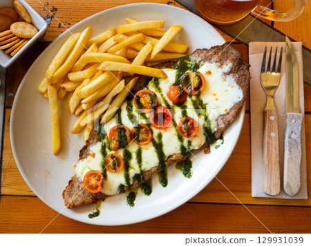 Appetizing Milanesa caprese veal served with french fries 129931039