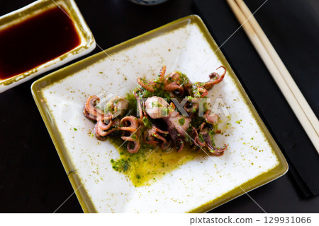 Small fried octopus with soy sauce. Japanese dish close up Small fried octopus with soy sauce. Japanese dish close up 129931066