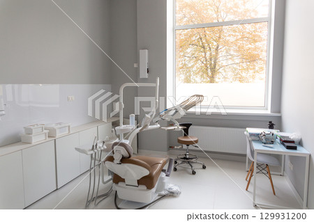 A bright modern dental office with a new patient chair and advanced equipment 129931200