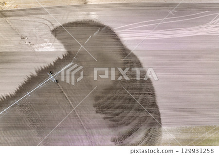 Spraying water on farmland ground for crop growth during period of drought. Sprinkler irrigation system watering farm field during dry season Spraying water on farmland ground for crop growth during period of drought. Sprinkler irrigation system watering farm field during dry season 129931258