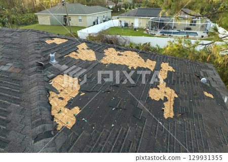 Natural disaster and its consequences. Hurricane Ian destroyed house roof in Florida residential area 129931355