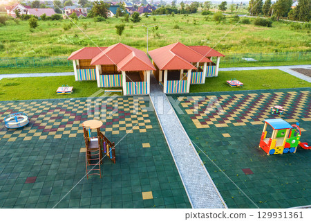 Aerial view of new alcove in kindergarten play yard with red tiled roof for outdoor children activities. 129931361