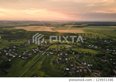 Aerial view of residential houses in suburban rural area at sunset Aerial view of residential houses in suburban rural area at sunset 129931386