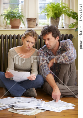 A couple is reviewing their financial documents at home, focusing on their budget and expenses A couple is reviewing their financial documents at home, focusing on their budget and expenses 129931831