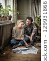 A Couple Deeply Engaged in Analyzing Documents Together in Their Cozy Living Room Space 129931866