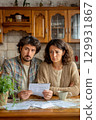 A couple at home reviews unsettling news, reflecting on their emotions and situation 129931867