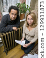 A Concerned Couple Reviewing Their Household Bills and Finances Together in Their Home 129931873