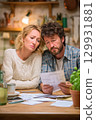 A Concerned Couple Engaged in the Activity of Reviewing Financial Documents at Home Together 129931881