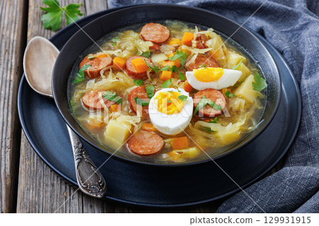 Polish sauerkraut soup with sausage in a bowl Polish sauerkraut soup with sausage in a bowl 129931915