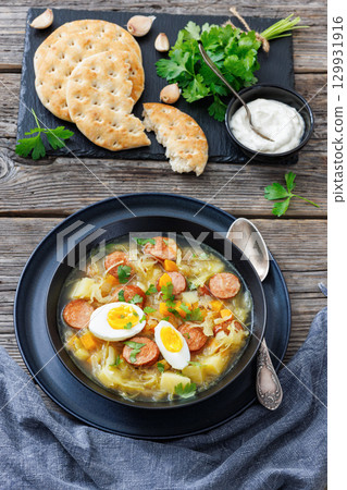 Polish sauerkraut soup with sausage in a bowl 129931916