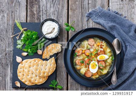 Polish sauerkraut soup with sausage in a bowl Polish sauerkraut soup with sausage in a bowl 129931917