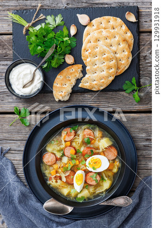 Polish sauerkraut soup with sausage in a bowl 129931918