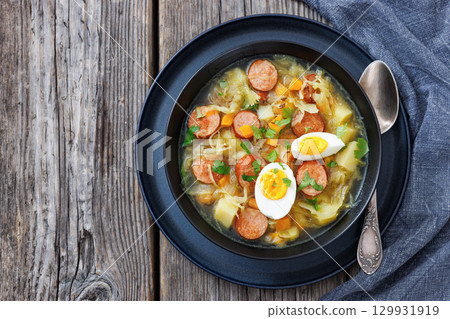 Polish sauerkraut soup with sausage in a bowl 129931919