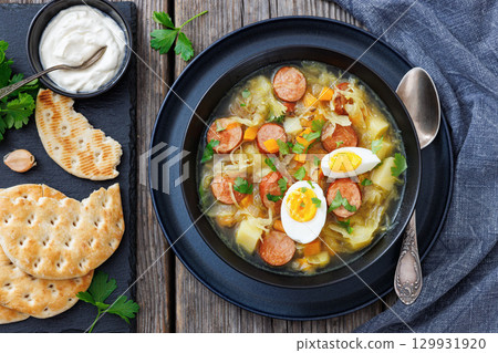 Polish sauerkraut soup with sausage in a bowl Polish sauerkraut soup with sausage in a bowl 129931920