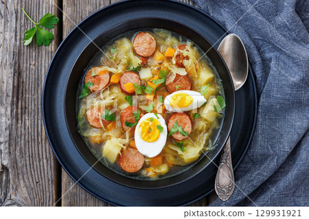 Polish sauerkraut soup with sausage in a bowl 129931921