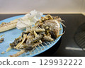 Dorado fish is presented on a blue plate, showcasing only its bones and remnants after being eaten 129932222