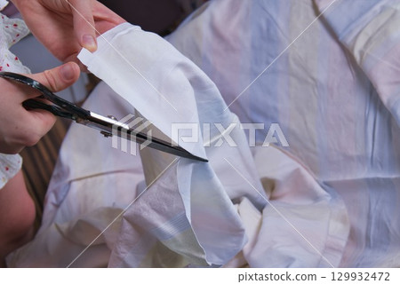 Woman cutting fabric ( side point of view close up) Woman cutting fabric ( side point of view close up) 129932472