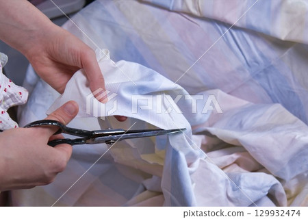 Woman cutting fabric ( side point of view close up) Woman cutting fabric ( side point of view close up) 129932474