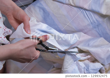 Woman cutting fabric ( side point of view close up) Woman cutting fabric ( side point of view close up) 129932475