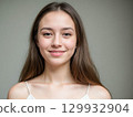 Smiling Young Woman Portrait on Gray Background 129932904