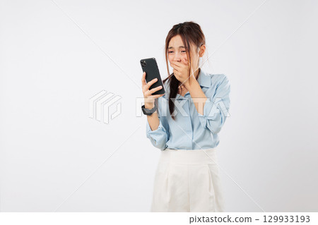 Asian woman shock surprise with phone emotion hold mouth worried after reading mobile news, reacts to shocking content on her phone experiencing disbelief, isolated studio white background Asian woman shock surprise with phone emotion hold mouth worried after reading mobile news, reacts to shocking content on her phone experiencing disbelief, isolated studio white background 129933193