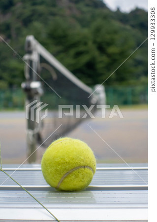 Tennis ball rolling on a tennis court 129933308