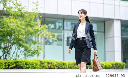 一位日本女商人自信地走在現代化辦公室前的全身肖像 129933493