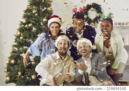 Portrait of cheerful young multiracial friends having fun together to beat of New Year's chimes. 129934108