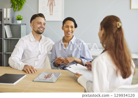 Woman doctor gynecologist consulting couple, encourages and supports that everything will be fine Woman doctor gynecologist consulting couple, encourages and supports that everything will be fine 129934120