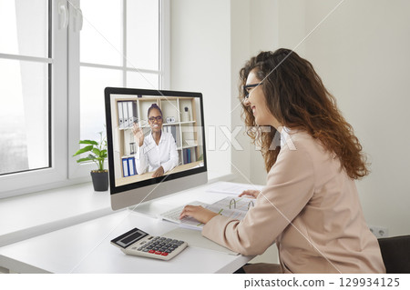Happy business woman or financial accountant having an online work meeting via a video call Happy business woman or financial accountant having an online work meeting via a video call 129934125