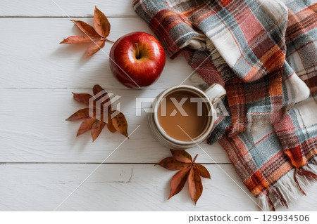 Autumn Flat Lay with Caramel Apple, Mug, Plaid Napkin, and Leaves 129934506