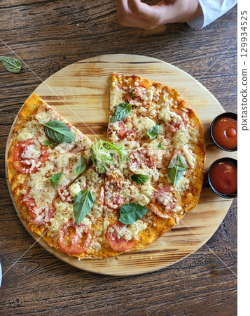 This is round of pizza on the table  129934525