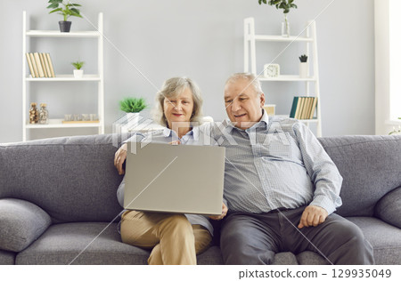 Happy Elderly Couple Using Laptop For Online Entertainment Happy Elderly Couple Using Laptop For Online Entertainment 129935049