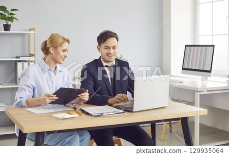 Business Colleagues Working Together On Accounting Using Laptop During Meeting Business Colleagues Working Together On Accounting Using Laptop During Meeting 129935064
