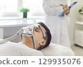 Man With Oxygen Mask Under Doctor Care In Hospital 129935076