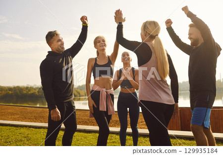 Sporting Friends Exchange High Five in the Park 129935184