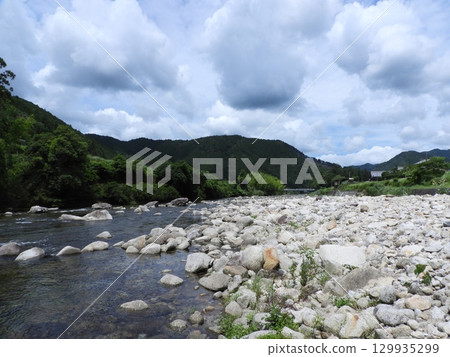 A mountain riverside landscape with a clear stream and summer sky 129935299