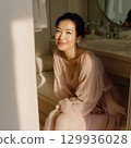 A stylish, beautiful Japanese woman relaxing by the window (square photo) 129936028