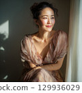 A stylish, beautiful Japanese woman relaxing by the window (square photo) 129936029