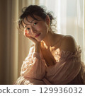 A stylish, beautiful Japanese woman relaxing by the window (square photo) 129936032